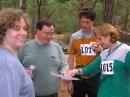 Jennifer, W5JEN (left), and Kenneth Harker, WM5R (second from left), organized this years national championships. They are reviewing the 80 meter runs of Charles Scharlau, NZ0I, and Nadia Scharlau (right). [Joe Moell, K0OV, Photo]