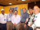 The IARU booth is a hotbed of activity. Here, IARU Incoming President Tim Ellam, VE6SH (second from left), meets with Gustavo de Faria Franco, PT2ADM (far left); Ramon Santoyo, XE1KK (to Ellam's right); Daniel Lamoureux, VE2KA; Dario Jurado, HP1DJ, and Orlando Perez Filho, PT2OP. [S. Khrystyne Keane, K1SFA, Photo]