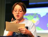 Student asking a question on a microphone at King George Elementary School.