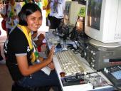 Student smiling by a computer setup.